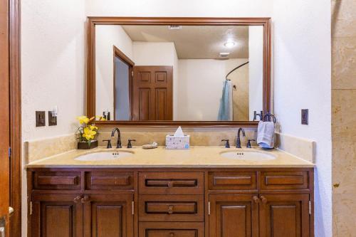 a bathroom with two sinks and a large mirror at Sonoran Sun Ground Floor - 104-W in Puerto Peñasco