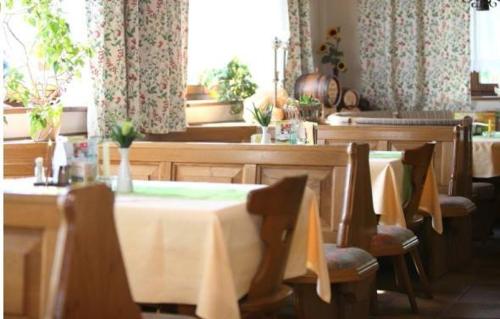 a dining room with tables and chairs and a window at Gasthof Steinerwirt in Heimhausen