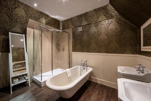 een badkamer met een bad, een wastafel en een douche bij Karma Lake Of Menteith Hotel in Aberfoyle