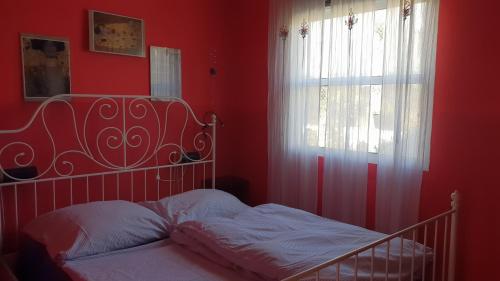 Dormitorio rojo con cama y ventana en CASA FLORES, en Los Llanos de Aridane