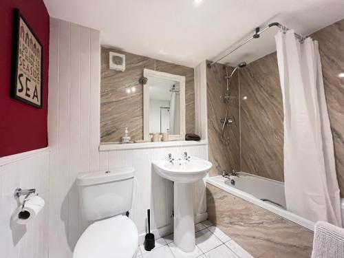 een badkamer met een toilet, een wastafel en een douche bij Quaint, cosy bolt hole in Cellardyke in Cellardyke
