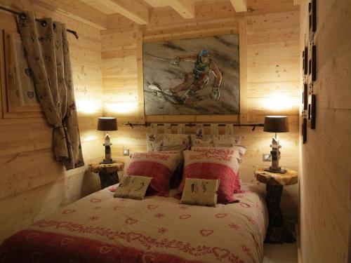 a bedroom with a bed with a painting on the wall at Chalet de la Royotte - Sauna & SPA in Gérardmer