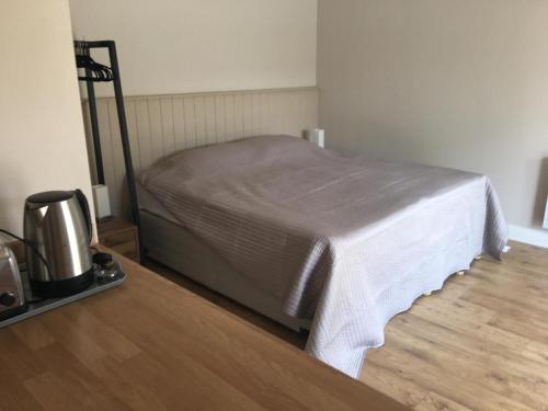 a bed in a room with a wooden floor at Bond End Road Annex Upton St Leonards - Ideal for Cheltenham Races in Matson