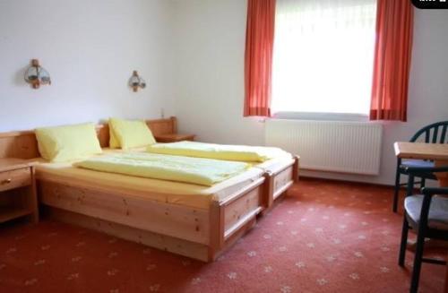 Schlafzimmer mit einem Bett, einem Tisch und einem Fenster in der Unterkunft Gasthof Steinerwirt in Heimhausen