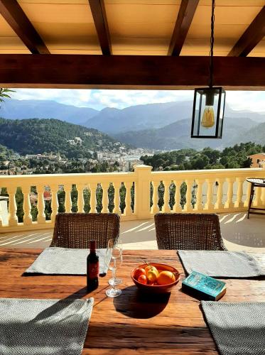 a table with a bowl of fruit and a bottle of wine at Casa Sol with private terrace, garden, pool, beautiful view in Port de Soller
