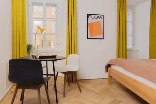 a bedroom with a bed and a table and chairs at Marktbar Studios - Boutique Aparthotel in Innsbruck