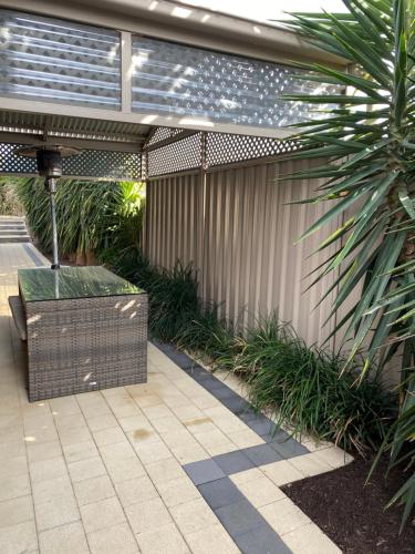 a patio with a bench and a fence with plants at Casavino Luxury Villa in McLaren Vale