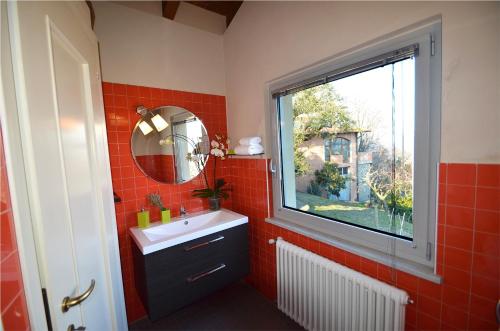 La salle de bains est pourvue d'un lavabo et d'une fenêtre. dans l'établissement Casa Brina Suites, à Cocconato