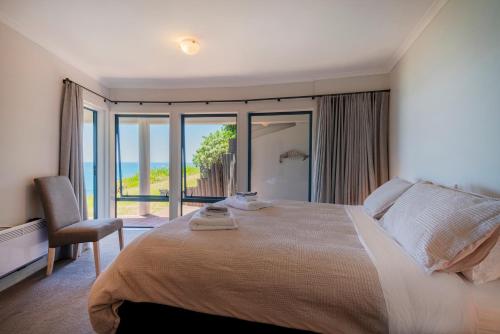 a bedroom with a bed with a view of the ocean at Oceana Heights Paradise - Beautiful 2 bdrm self contained apartment in Tairua