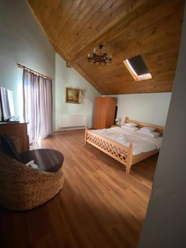 une chambre avec un grand lit et un plafond en bois dans l'établissement Hasienda, à Râșnov