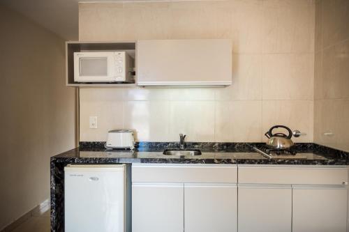 eine Küche mit einer Spüle und einer Mikrowelle in der Unterkunft Altos del Champaqui in Villa Carlos Paz