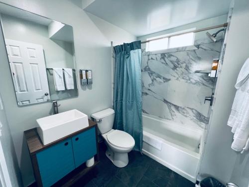 ein Bad mit einem Waschbecken, einem WC und einer Dusche in der Unterkunft Harbor Inn in Harbor City