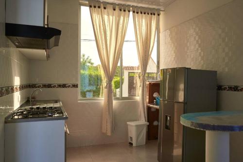 吉拉爾的住宿－Casa vacacional Girardot 5 habit，厨房配有冰箱和窗户。