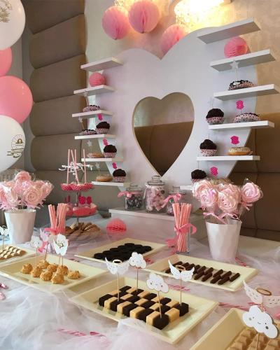 a table with pastries and cupcakes and a heart wall at Biały Dom Henlex Hotel Restauracja in Poznań