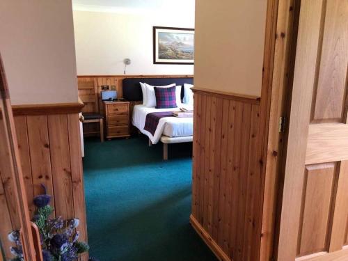 a bedroom with a bed and a bed and a room with a bed sqor at Binnilidh Mhor B&B in Glenmoriston