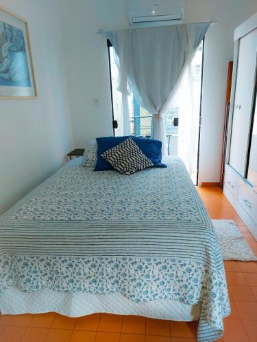 1 dormitorio con 1 cama grande y edredón azul en Vista&Aconchego en Santos