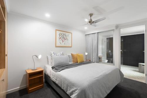 a white bedroom with a bed and a window at City Courtyard One Apartment in Mount Gambier