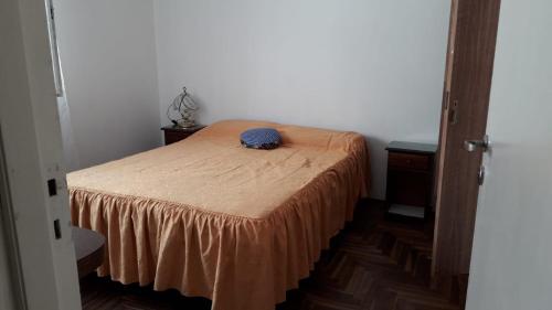 Dormitorio pequeño con cama con sábana marrón en Departamento para vacaciones en Mar del Plata. en Mar del Plata