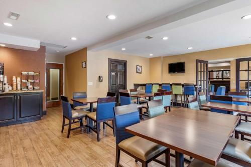 a restaurant with wooden tables and blue chairs at Comfort Inn Biltmore West in Asheville