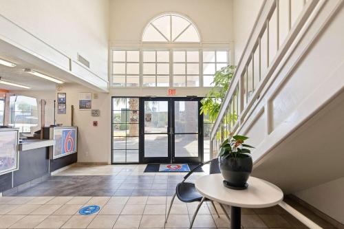 a hallway with a table and a potted plant in a building at Studio 6 Tucson, AZ - North in Tucson