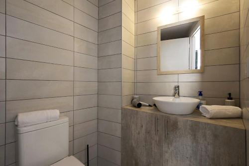 a bathroom with a sink and a mirror and a toilet at Casa di Roza in Corfu
