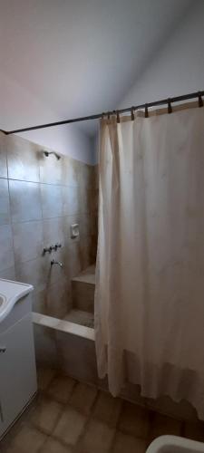 uma casa de banho com uma cortina de chuveiro e uma banheira em Apartamento Virgen del Cerro Salta em Salta
