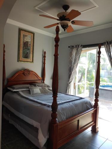 a bedroom with a bed with a ceiling fan at Cape Paradise B & B - Your Luxury Tropical Retreat in Cape Coral