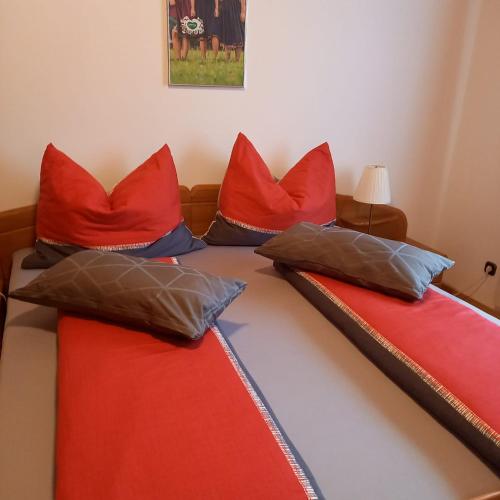 a bed with red and blue pillows on it at ALTSTADT-APARTMENTS Bad Radkersburg - Ihr Zuhause auf Reisen in Bad Radkersburg