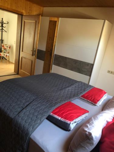 a bedroom with a large bed with red sheets at ALTSTADT-APARTMENTS Bad Radkersburg - Ihr Zuhause auf Reisen in Bad Radkersburg