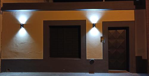 dos luces en el costado de una pared con una puerta en Casa Termas en Termas de Río Hondo
