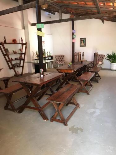 a group of wooden tables in a room at Residencial Vovó Lelé in Imbassai