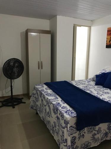 a bedroom with a bed with a blue and white blanket at Residencial Vovó Lelé in Imbassai