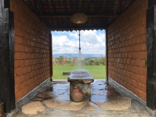 a fountain in a building with a view of a field at Pousada Sete Quedas in Carrancas