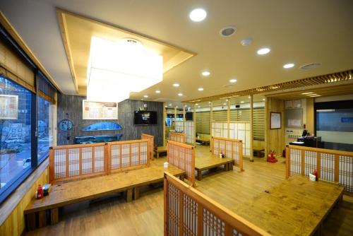 a restaurant with wooden benches and a large window at Dunsan Graytone Hotel in Daejeon