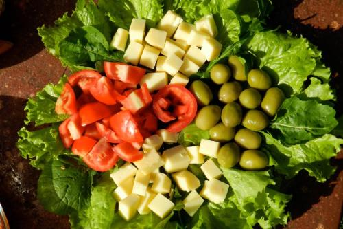 a salad with vegetables and cheese on a table at Hospedagem Sabor Da Trilha in Vale do Capao