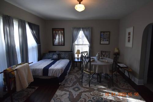 1 dormitorio con cama, mesa y ventana en Bungalow in Bloom en French Lick