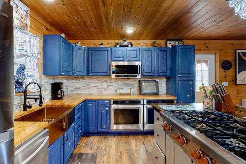a kitchen with blue cabinets and a stove top oven at Lucky Clover Cabin in Blairsville