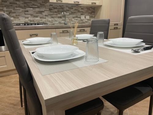 a wooden table with white plates on top of it at B&B Miramare Suite Borgo in Taranto