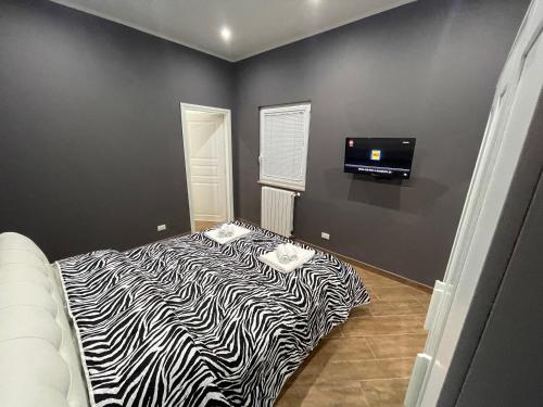 a zebra print bed in a room with a tv at B&B Miramare Suite Borgo in Taranto