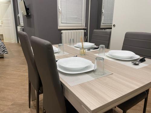 a wooden table with chairs and plates on it at B&B Miramare Suite Borgo in Taranto