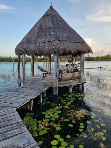 a hut on a dock on a body of water at Eco Hotel Casa Corazón Bacalar in Bacalar