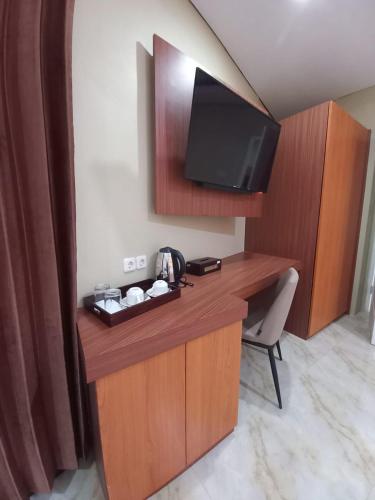 a hotel room with a desk with a television on it at Grand Avira Hotel in Batu Merah