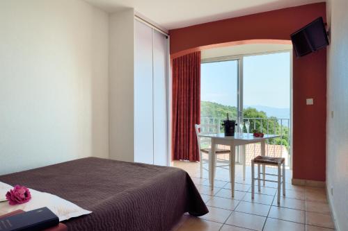 um quarto com uma cama e uma varanda com uma mesa em Hotel Alata em Alata