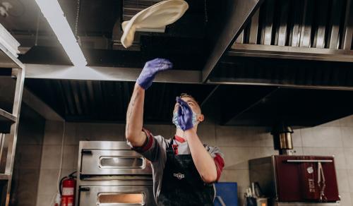 a woman is reaching for a shelf in a kitchen at Loft Hotel in Bukovel