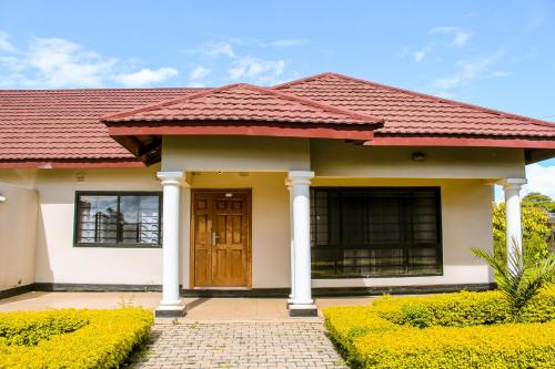 a small house with a red roof at Mwaiseni Maisonettes apartments in Ndola