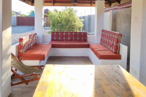 a porch with two benches and a table and chairs at Mwaiseni Maisonettes apartments in Ndola