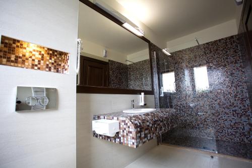 W łazience znajduje się umywalka i lustro. w obiekcie Hotel Relax Craiova w Krajowej