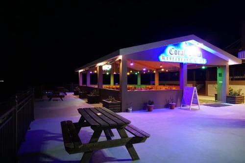a restaurant with a bench in front of it at night at Coral View Hotel & Resort in Caye Caulker