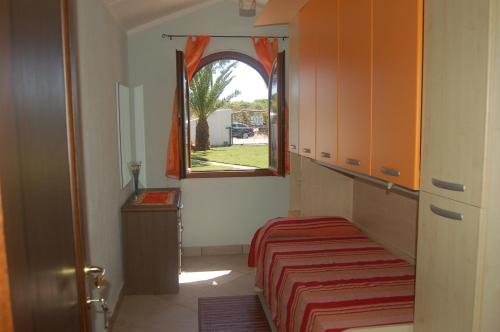 a small bedroom with a bed and a window at Relax al Mare in Olbia