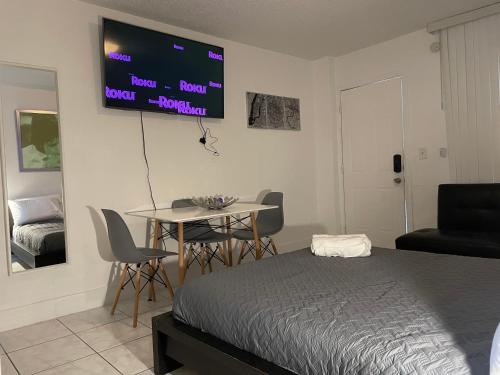 1 dormitorio con 1 cama y 1 mesa con sillas en trendy Studios in Hollywood, en Hollywood